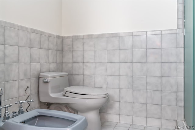 bathroom with tile walls, walk in shower, a bidet, and toilet