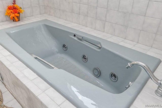 interior details featuring a jetted tub and a sink