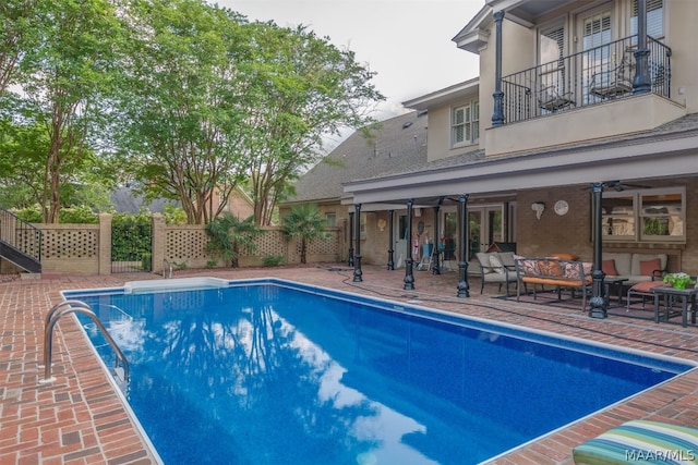 view of pool with ceiling fan, outdoor lounge area, and a patio area