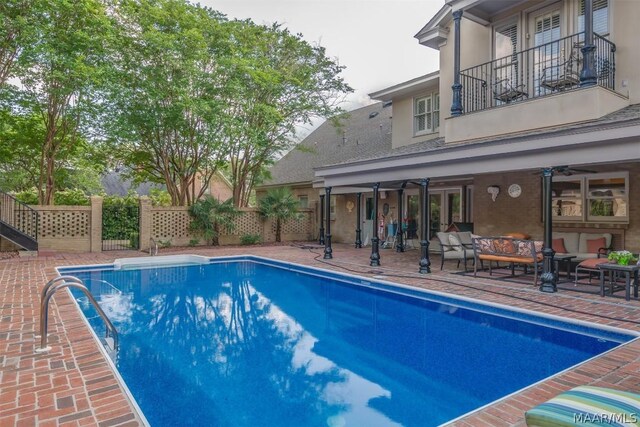 view of swimming pool featuring a patio area, ceiling fan, fence, and an outdoor living space