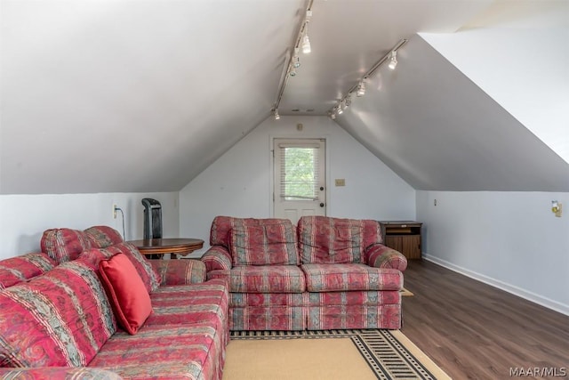 living room featuring vaulted ceiling, baseboards, and wood finished floors