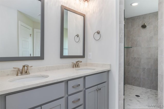 bathroom with vanity and tiled shower