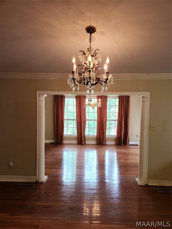 unfurnished dining area featuring plenty of natural light, a chandelier, and dark hardwood / wood-style floors