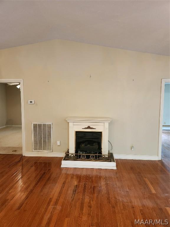 unfurnished living room featuring wood-type flooring and vaulted ceiling