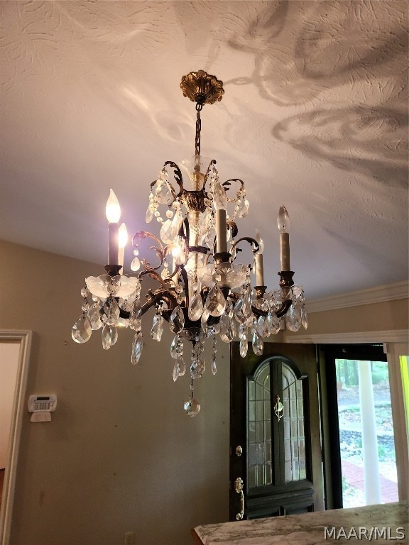 interior details featuring crown molding and an inviting chandelier