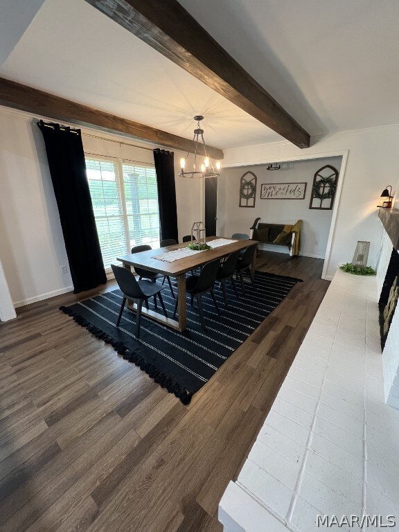 dining area with dark wood-type flooring, a chandelier, and beam ceiling