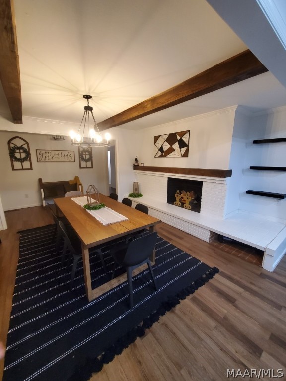 living room featuring beamed ceiling, hardwood / wood-style floors, and an inviting chandelier