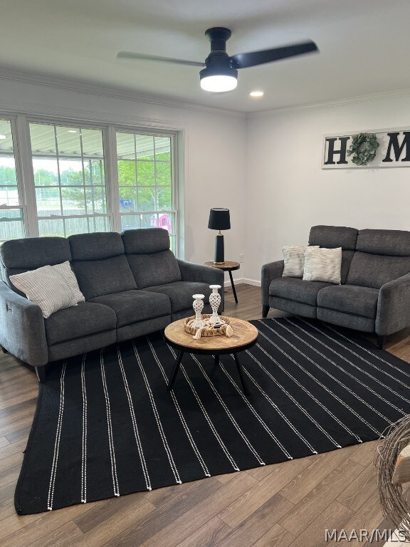 living room featuring ornamental molding, hardwood / wood-style floors, and ceiling fan