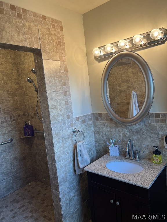 bathroom with tile walls, backsplash, tiled shower, and vanity