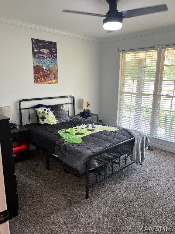 carpeted bedroom featuring crown molding and ceiling fan