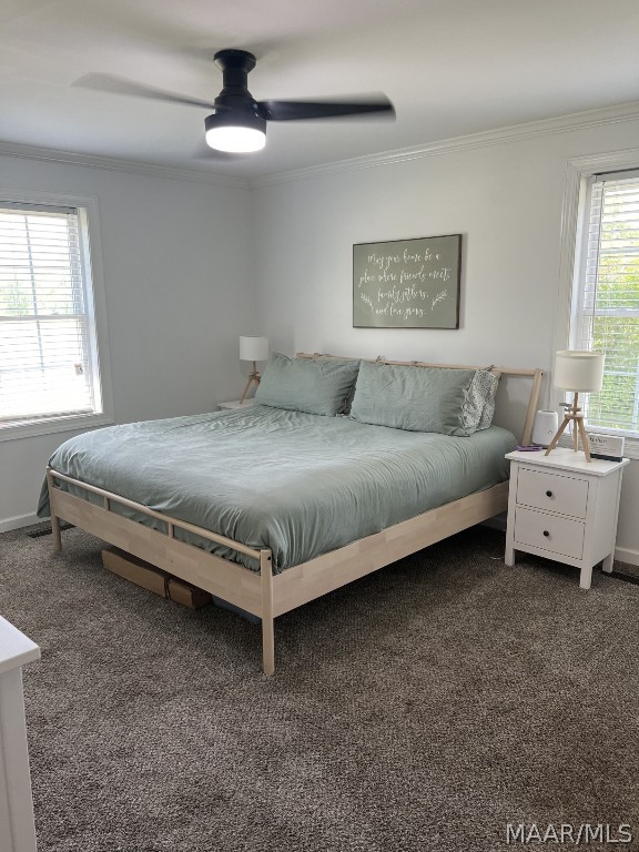 carpeted bedroom featuring crown molding and ceiling fan