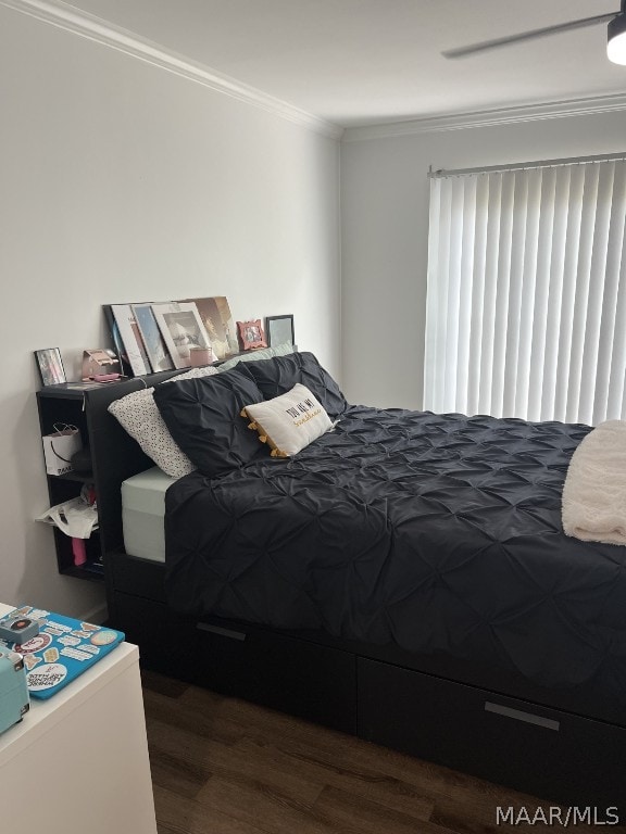 bedroom with dark hardwood / wood-style floors and ornamental molding