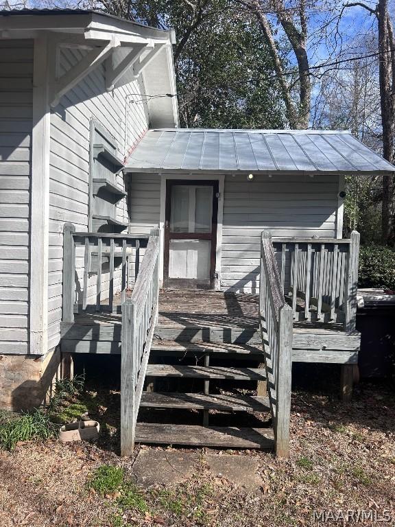 exterior space with a deck and metal roof