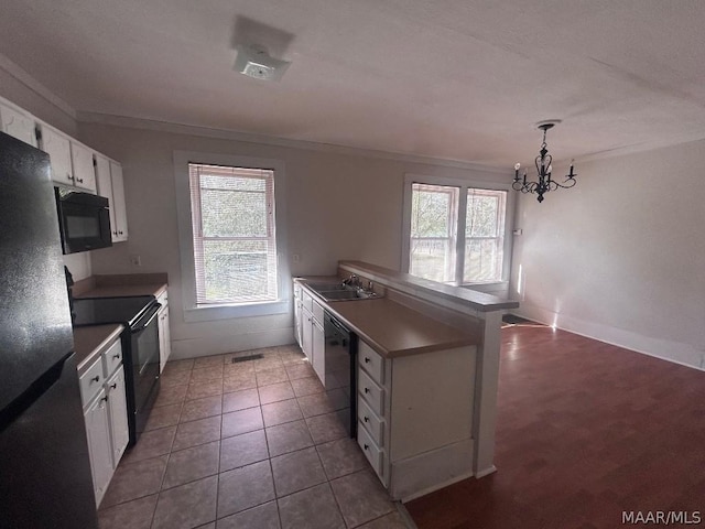 kitchen featuring black appliances, dark countertops, a sink, and white cabinets