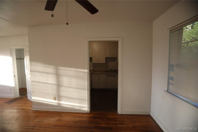 unfurnished room with ceiling fan, dark wood-type flooring, and sink