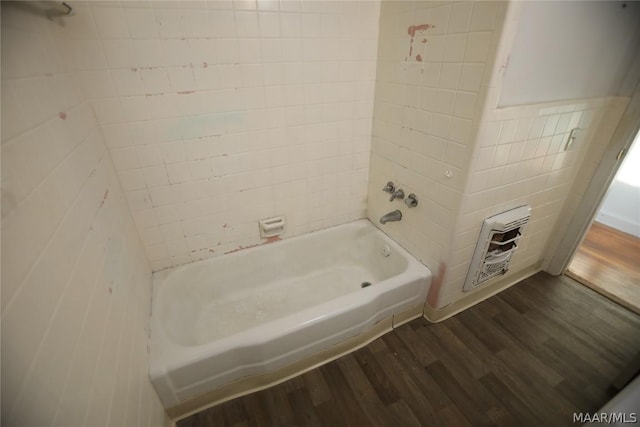 bathroom featuring tile walls, hardwood / wood-style flooring, and tiled shower / bath