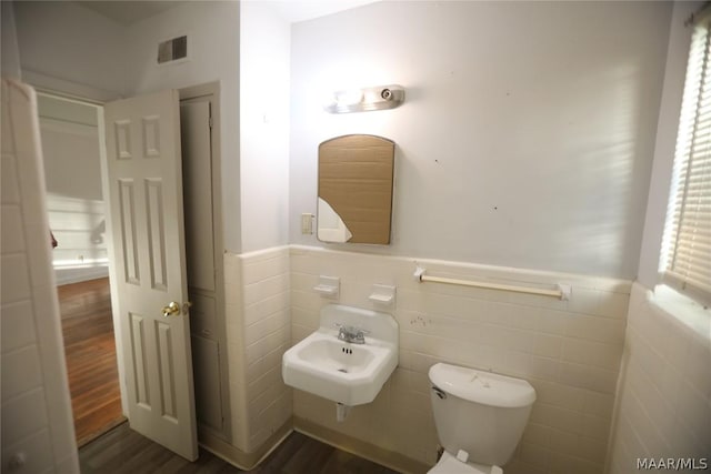 bathroom with sink, tile walls, toilet, and hardwood / wood-style floors