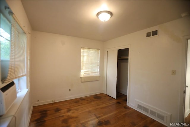 unfurnished bedroom featuring dark wood-type flooring and a closet