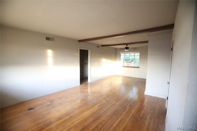 empty room with beam ceiling and wood-type flooring