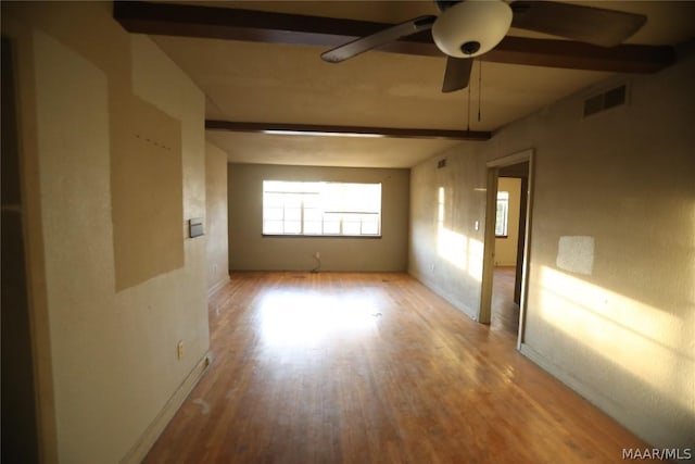 unfurnished room with ceiling fan, beamed ceiling, and light hardwood / wood-style flooring