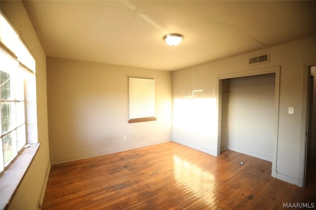 unfurnished bedroom with a closet and hardwood / wood-style floors