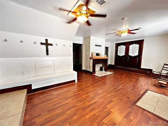 interior space with ceiling fan, wood-type flooring, and vaulted ceiling