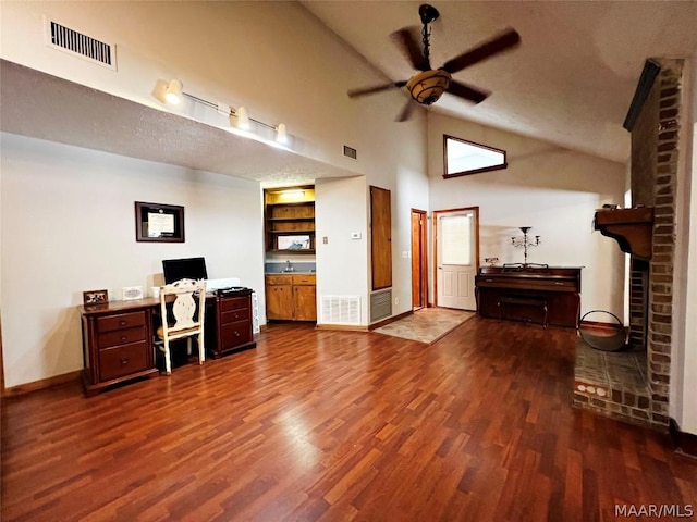 office space with a textured ceiling, ceiling fan, dark wood-type flooring, sink, and high vaulted ceiling