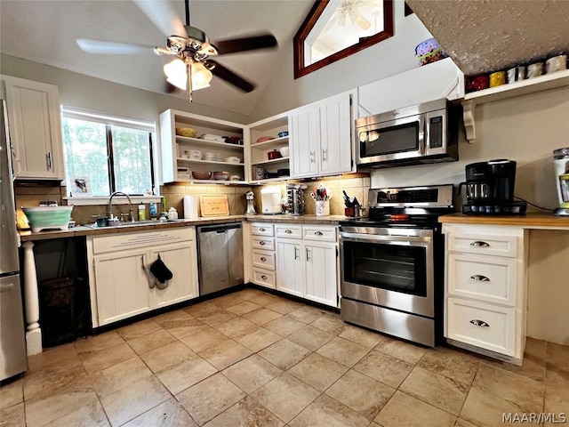 kitchen featuring white cabinets, appliances with stainless steel finishes, vaulted ceiling, and sink