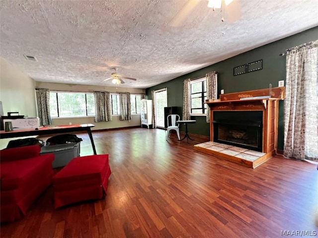 living room featuring a fireplace, hardwood / wood-style floors, and a textured ceiling