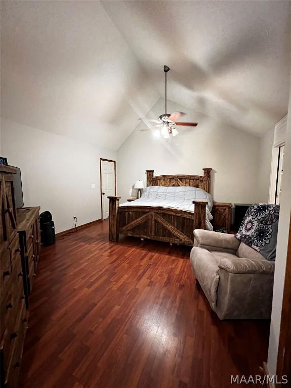 bedroom featuring ceiling fan, dark hardwood / wood-style flooring, and lofted ceiling