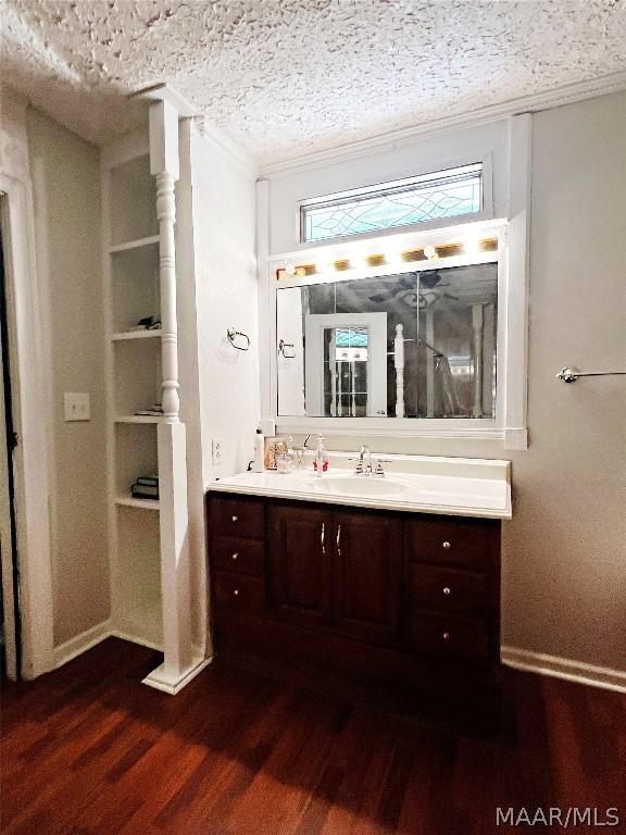 bathroom featuring vanity, hardwood / wood-style floors, a textured ceiling, and crown molding