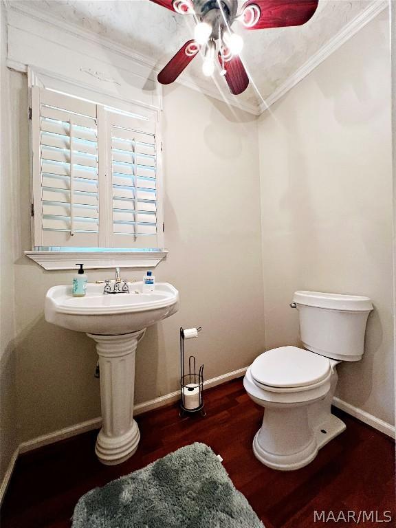 bathroom with wood-type flooring, toilet, and crown molding