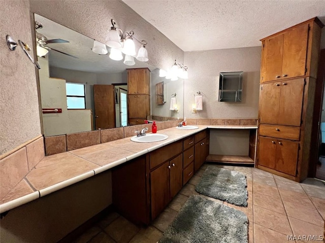 bathroom featuring tile patterned floors, ceiling fan, a textured ceiling, and vanity