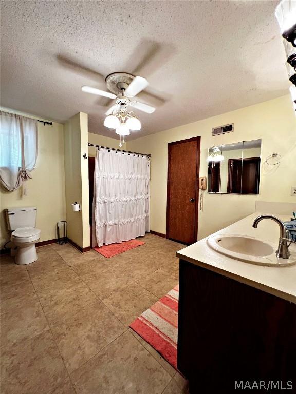 bathroom featuring vanity, ceiling fan, toilet, a textured ceiling, and radiator heating unit