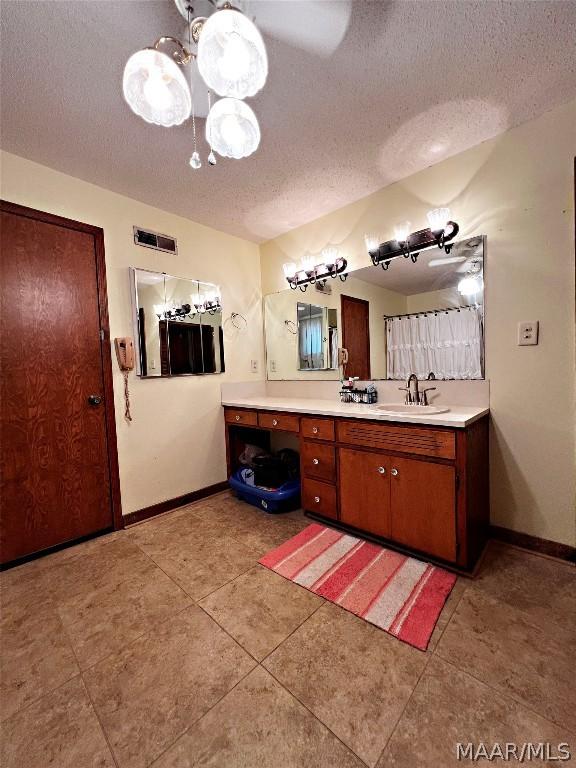 bathroom featuring tile patterned floors, vanity, and a textured ceiling