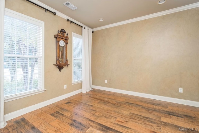 spare room featuring wood-type flooring and ornamental molding