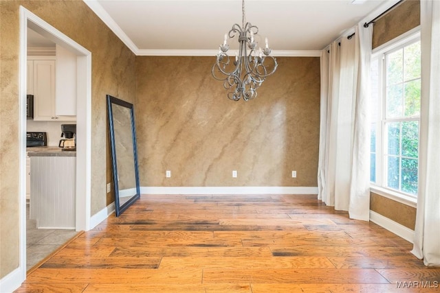 unfurnished dining area with crown molding, light hardwood / wood-style floors, and a notable chandelier