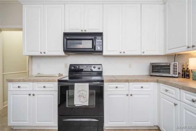 kitchen with black appliances, decorative backsplash, light tile patterned flooring, and white cabinets