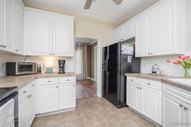 kitchen with white cabinetry, ceiling fan, black refrigerator with ice dispenser, and ornamental molding