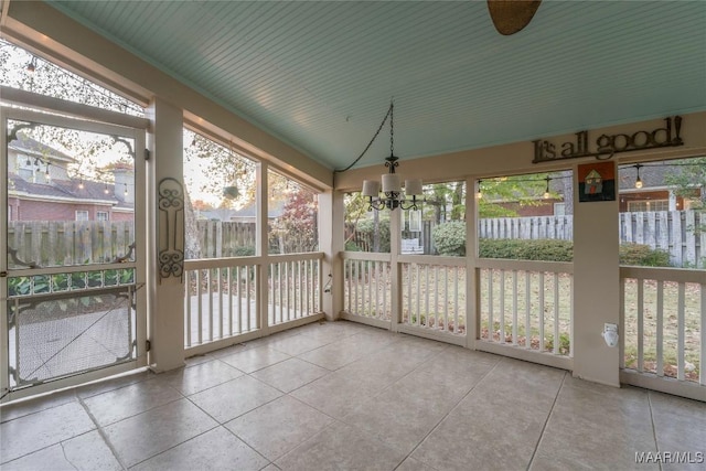 unfurnished sunroom with a chandelier and lofted ceiling