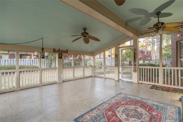 unfurnished sunroom featuring plenty of natural light, lofted ceiling with beams, and ceiling fan with notable chandelier