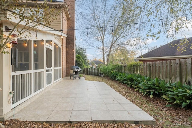 view of patio with a grill and a sunroom