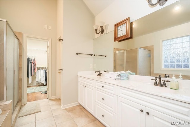 bathroom featuring vanity, tile patterned floors, walk in shower, and lofted ceiling