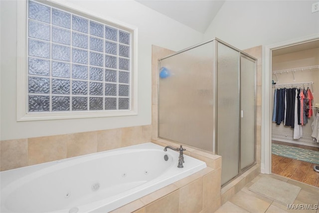 bathroom featuring tile patterned flooring, independent shower and bath, and lofted ceiling