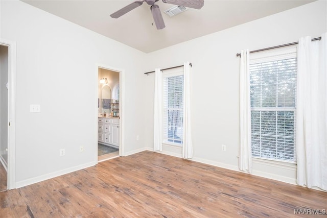 unfurnished room featuring ceiling fan, a healthy amount of sunlight, and hardwood / wood-style flooring