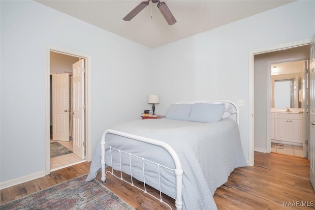 bedroom with ceiling fan, ensuite bathroom, and hardwood / wood-style flooring