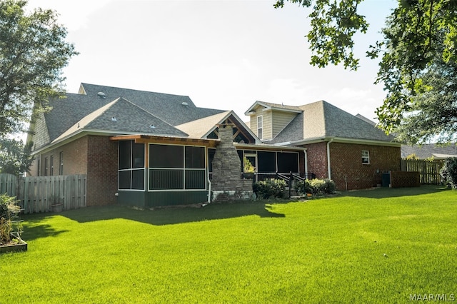 rear view of property featuring a lawn and a sunroom