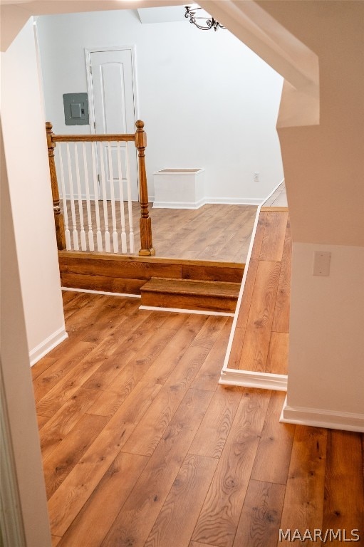 stairway featuring electric panel and hardwood / wood-style floors