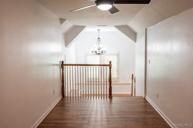 hall featuring a notable chandelier, lofted ceiling, and dark wood-type flooring