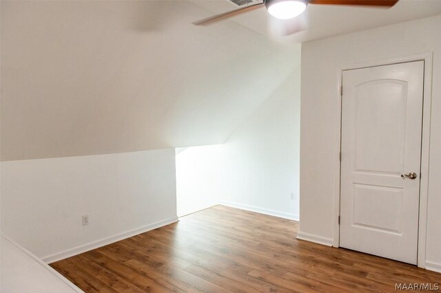 additional living space featuring hardwood / wood-style flooring, vaulted ceiling, and ceiling fan